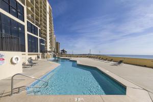 a swimming pool in front of a building next to the beach at Phoenix II 2011 in Orange Beach