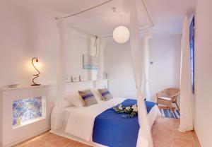 1 dormitorio blanco con 1 cama con manta azul en Blue Home, en Sitges