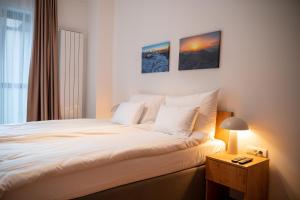 a bedroom with a bed and a night stand with a lamp at Apartments Nomad Bjelašnica in Bjelašnica