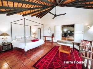 a bedroom with a large bed and a living room at 24 Degrees South Country Estate in Hoedspruit