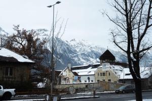 um edifício com uma montanha coberta de neve ao fundo em Wohnen auf Zeit - Studiowohnung Innsbruck em Innsbruck
