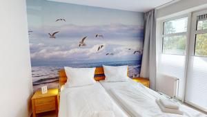 ein Schlafzimmer mit einem Bett mit Vögeln, die über das Meer fliegen in der Unterkunft Grüntal-Residenz Haus II App. 2 in Grömitz