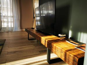 een grote flatscreen-tv op de top van een houten tafel bij Serenity Suite in Sinaia