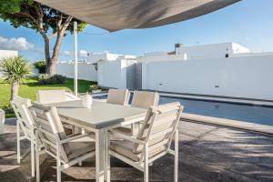 a white table and chairs on a patio with a pool at Chill out of City 2 in Chiclana de la Frontera