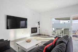 a living room with a couch and a tv at Chill out of City 2 in Chiclana de la Frontera