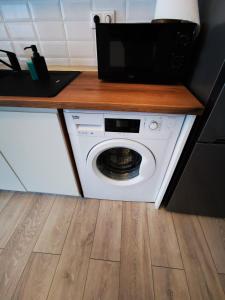 uma máquina de lavar roupa branca numa cozinha com um balcão em Serenity Suite em Sinaia