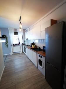 a kitchen with white cabinets and a washer and dryer at Serenity Suite in Sinaia