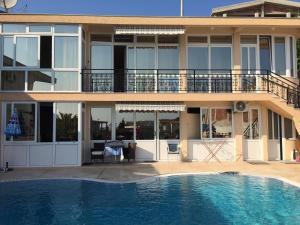 a house with a swimming pool in front of a building at Apartments Nensy in Bar