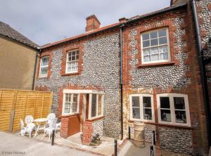 a brick building with a table and chairs in front of it at Annies, 30 Station Road in Sheringham