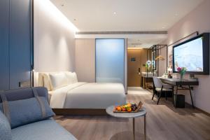 a hotel room with a bed and a table with a bowl of fruit at Atour Hotel Shenyang Zhongshan Plaza in Shenyang
