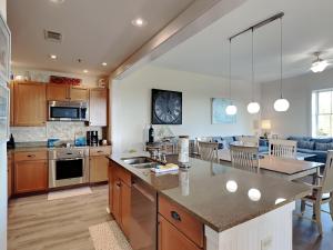a kitchen and living room with a table and a counter at Redfish Village m2-430 in Blue Mountain Beach