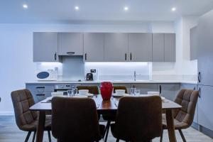 a dining room with a table and chairs and a kitchen at Luxury 2 bed flat in a new block in East Acton in London