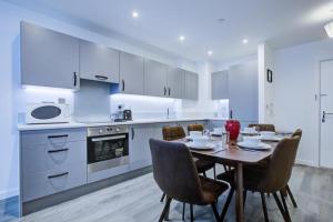a kitchen with a table and chairs in a kitchen at Luxury 2 bed flat in a new block in East Acton in London