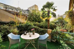 einen Tisch und Stühle auf dem Rasen im Garten in der Unterkunft "Maison 1850 Paris 18" Chambre G avec terrasse et parking en option in Paris