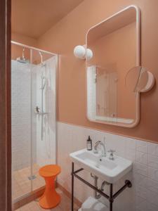 y baño con lavabo y ducha con espejo. en Hôtel Saint-André des Arts, en París
