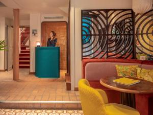 a woman talking on a cell phone in a lobby at Hôtel Saint-André des Arts in Paris