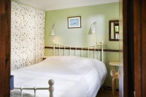 a bedroom with a bed with a white bedspread at Y Caban at Wig Farm near Llangrannog in Llandysul