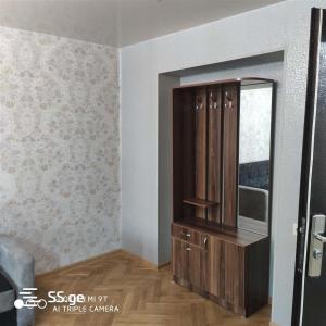 Cette chambre comprend un miroir et une armoire en bois. dans l'établissement apartment, à Tbilissi