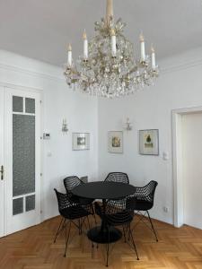 a dining room with a table and chairs and a chandelier at Atelier Lomani in Vienna
