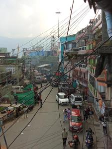 een uitzicht op een straat met auto's en mensen bij Benus Darjeeling Home A Backpacker Hub in Darjeeling
