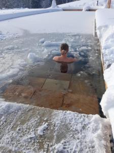 a man is standing in a body of water at Ferienhaus Pliescherhof in Turnau