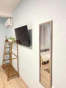 a mirror and a television on a wall next to a ladder at Shkodra Guest House in Shkodër