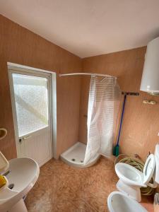 a bathroom with a shower and a toilet and a sink at Shkodra Guest House in Shkodër