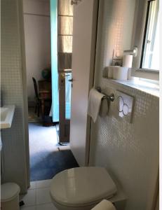 La salle de bains blanche est pourvue de toilettes et d'une fenêtre. dans l'établissement "Maison 1850 Paris 18" Chambre G avec terrasse et parking en option, à Paris