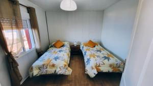 Habitación pequeña con 2 camas y ventana en Casa el Monte, en San Juan del Reparo