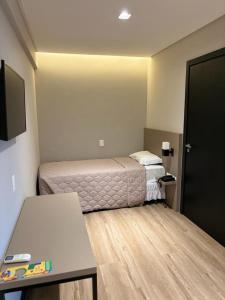 Habitación pequeña con cama y mesa en Arco do Sol Park Hotel, en Camboriú
