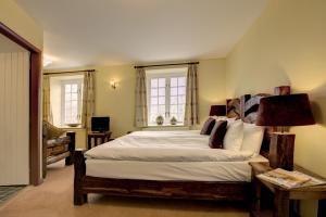 a bedroom with a large bed and two windows at Lowthwaite B&B in Watermillock
