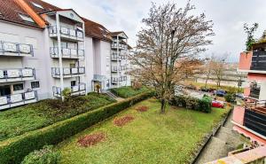 an apartment building with a tree in the yard at SCANDIC-Apartment, Balkony, Free Coffee, 80m2 in Pforzheim