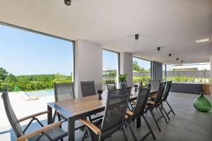 RajkiにあるModern villa Damian with jacuzzi near Porecの木製のテーブルと椅子のあるダイニングルーム