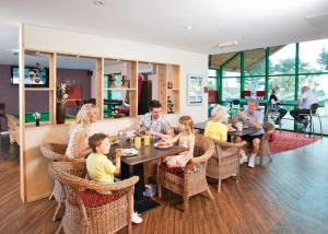 eine Gruppe von Menschen, die an einem Tisch in einem Restaurant sitzen in der Unterkunft Luxury 3 bedroom Maple View Lodge, Newquay, Cornwall in Newquay