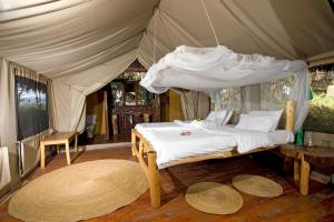een slaapkamer met een bed in een tent bij Migunga Tented Camp in Mto wa Mbu