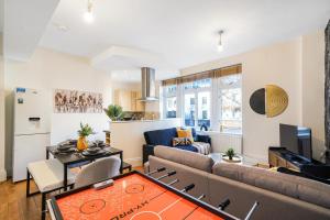 a living room with a couch and a table at Central Hackney Abode - Balcony in London