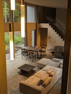 a living room with a couch and tables and stairs at ASH Villa 富士河口湖 in Fujikawaguchiko