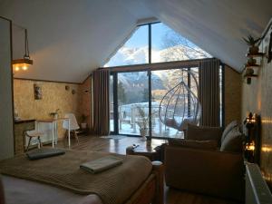 a bedroom with a bed and a large window at Kazbegi cottages qabarjina in Kazbegi