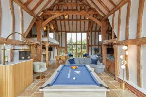 a barn with a pool table in the middle of a room at Mulberry Barn, Great Sampford in Great Sampford