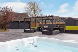 a backyard with a hot tub and a grill at Mulberry Barn, Great Sampford in Great Sampford