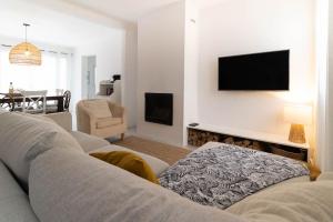 salon z kanapą i telewizorem na ścianie w obiekcie Villa provençale avec piscine w mieście Velaux