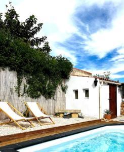 para krzeseł, stół i basen w obiekcie Villa provençale avec piscine w mieście Velaux
