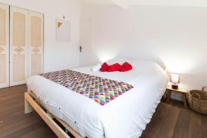 sypialnia z dużym białym łóżkiem z czerwonymi poduszkami w obiekcie Villa provençale avec piscine w mieście Velaux