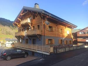 a building with a car parked in front of it at CHALET CHARMING BED and BREAKFAST in Les Gets