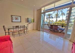 uma sala de estar com uma mesa e cadeiras e uma varanda em Skol 2A Amazing 2 Bedroom Apartment Skol Marbella em Marbella