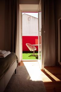 a bedroom with a door open with a chair outside at Campolide Charm Apartments in Lisbon