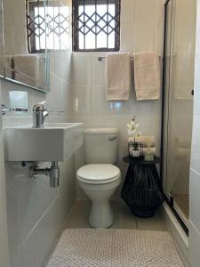 een badkamer met een wit toilet en een wastafel bij Barcalla Hotel Apartments in Maseru