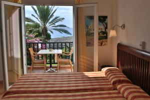 a bedroom with a bed and a balcony with a table at Apartamentos Parque Mar in Cala d´Or