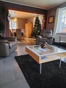 Sala de estar con mesa de centro y árbol de Navidad en Gîte Wibrin-Achouffe, en Houffalize