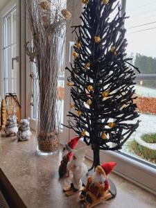 Un árbol de Navidad sentado en una mesa junto a una ventana en Gîte Wibrin-Achouffe, en Houffalize